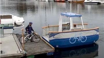 Radfahrer besteigt eine kleine Fähre.