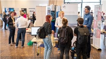 Studenten stehen vor Infoständen.