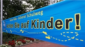 Ein Transparent mit der Aufschrift «Achten Sie auf Kinder!» ist am 03.08.2017 bei der Verkehrssicherheitsaktion «Kleine Füße - sicherer Schulweg» des Niedersächsischen Kultusministeriums vor der Mira Lobe Grundschule in Hannover (Niedersachsen) befestigt.