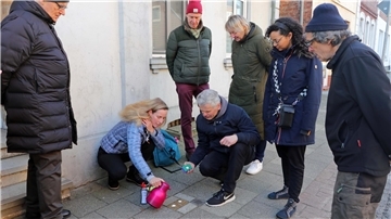 Ines Olschewski reinigt die Stolpersteine in der Langen Straße.
