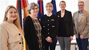 Olena Palahnyuk, Doris Ammermann,  Hannah-Sophie Heldberg, Maren Würger, Marco Witthohn stehen in einer Reihe vor einem Fenster. Hinter ihnen stehen Flaggen. 