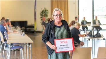 Ingrid Zahn, Leiterin des Familienzentrums „Louise-Schroeder-Straße“, präsentiert im Ausschuss für Bürgerbeteiligung das Plakat „3798 Stimmen“ für den Erhalt der Familienzentren.