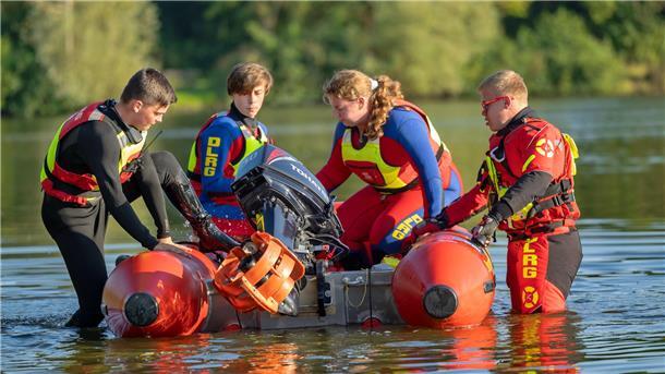 Vier DLRG-Jugendliche steigen in ein Schlauchboot.
