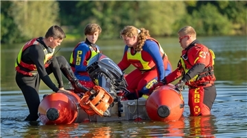 Vier DLRG-Jugendliche steigen in ein Schlauchboot.