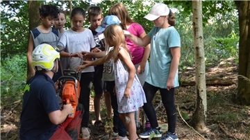 Interessiert schauten sich die Kinder die Kettensäge an. Die Zähne werden nach der Tagesarbeit geschärft. 