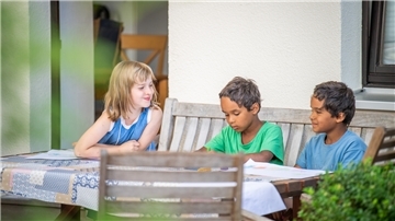 Yolanda Euler (von links) sitzt mit Ezra und Nathan Levinson im Garten beim Malen. 