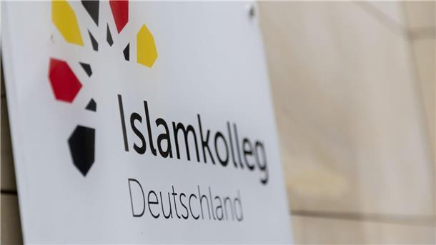 Absolventen des Islamkolleg Deutschland bekommen Zertifikate „Islamkolleg Deutschland“ steht auf einem Schild an einem Gebäude.