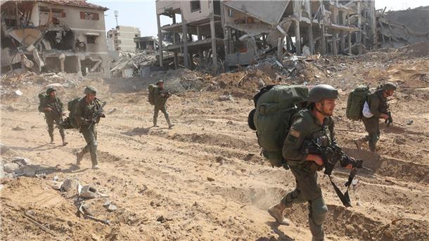 Gaza-Krieg: Neuer Anlauf im Ringen um Feuerpause Israelische Soldaten marschieren während einer Bodenoffensive durch den Ort.