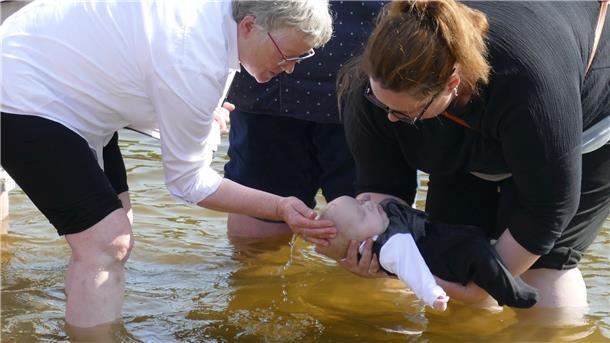 Ist es Tom oder ist es Theo? Jedenfalls einer der beiden Zwillinge wird von der Taufpatin (rechts) in Händen gehalten, während Pastorin Christa Maschke ihn mit Seewasser beträufelt.