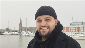 Ein Mann mit Mütze steht am Neuen Hafen