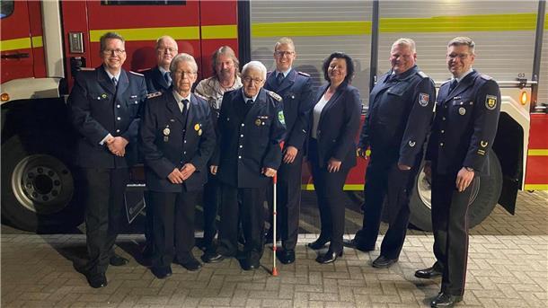 Mitglieder der Ortsfeuerwehr Sievern stehen vor einem Löschfahrzeug. 