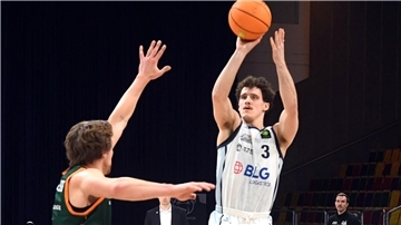Ein Basketballer wirft auf den Korb.