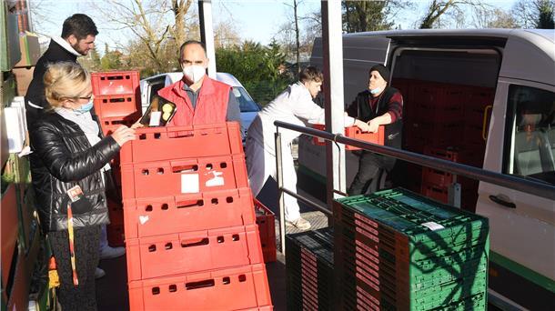Kisten und Menschen vor einem Transporter.