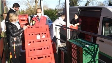 Kisten und Menschen vor einem Transporter.