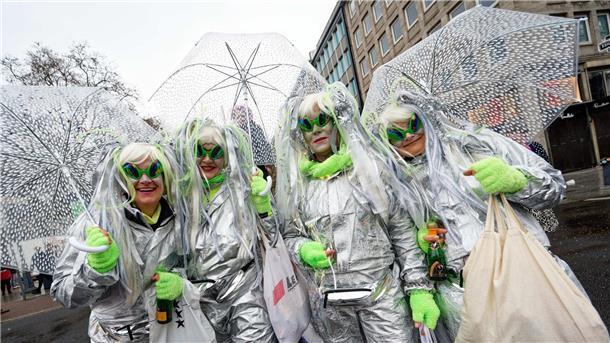 „Make Alaaf not war“: Karneval wieder ohne Corona-Regeln Jecken schützen sich beim traditionellem Kö-Treiben auf der Düsseldorfer Königsallee mit Schirmen vor dem Regen.