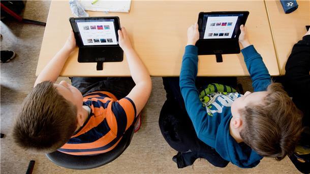 Zwei Schüler lernen mit iPads im Unterricht.