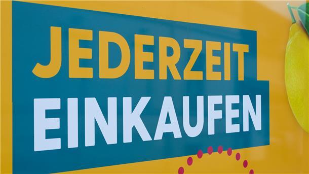 In großen Buchstaben steht auf einem Aushang "JEDERZEIT EINKAUFEN".