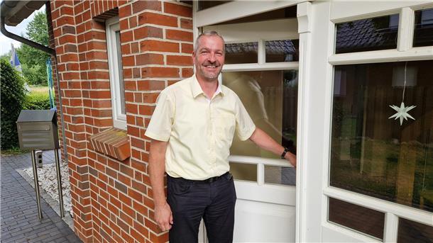 Zwischen Rat, Familie und Beruf: So ist Jens Behrens‘ Alltag als Bürgermeister Ein Mann steht in einer Haustür und lächelt in die Kamera.