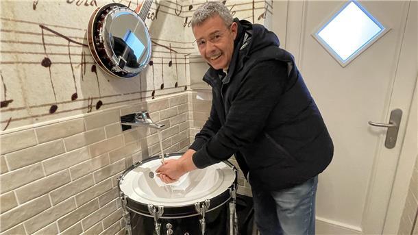 Ein Mann wäscht sind an einer zum Waschbecken umfunktionierten Basstrommel die Hände. Es ist der Tossenser Konzertmuschel-Betreiber Jens Hillers. 