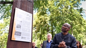 Joe Chialo (CDU), Berliner Kultursenator, betrachtet die neu eingeweihte Mahn- und Erinnerungsstele am ehemaligen „Afrika-Haus“ in Berlin.