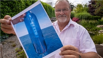 Jörg Wanke zeigt ein Foto seiner Flaschenpost.