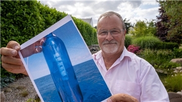 Jörg Wanke zeigt ein Foto seiner Flaschenpost. Die fand ein Mann aus dem Land USA nun nach zehn Jahren.