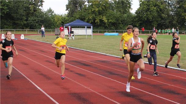 W-12-Läuferinnen sprinten über die Tartanbahn.