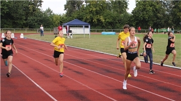 W-12-Läuferinnen sprinten über die Tartanbahn.