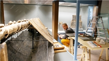 Johannes Schu, archäologischer Restaurator, legt Hand an. Die Arbeiten für die neuen Vitrinen laufen auf Hochtouren. Auch der als Sarg genutzte Einbaum aus dem frühen 5. Jahrhundert erhält ein neues gläsernes Zuhause.