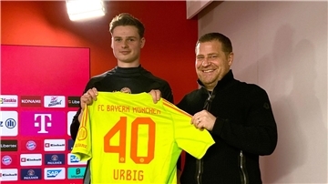 Jonas Urbig (l) präsentiert das Bayern-Trikot mit der Nummer 40 bei seiner Vorstellung mit Sportvorstand Max Eberl.