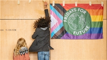 Junge Klima-Aktivisten haben sich in der Aula der Schollschule versammelt, um ein Zeichen gegen die Klimakrise und den Einsatz fossiler Brennstoffe zu setzen.