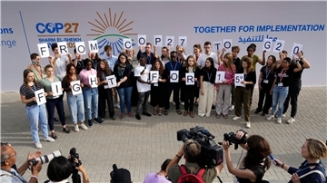 Junge Klimaaktivisten halten in Scharm el Scheich Schilder mit der Aufschrift „From COP27 To G20 Fight For 1.5°“.