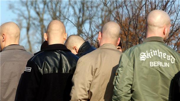 Junge Neonazis stehen während einer Demonstration zusammen.
