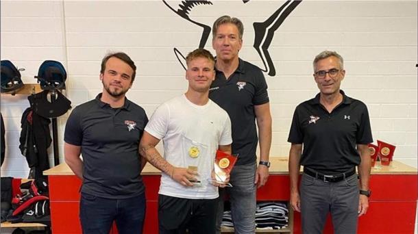 Justin Büsing bekam die Auszeichnungen von Matthias Baldys (v. li.), Direktor Hockey Operations bei den Kölner Haien, Cheftrainer Uwe Krupp und Geschäftsführer Rodion Pauels überreicht.