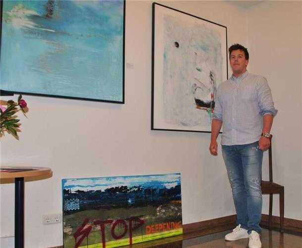 Justin Hofschildt vor den Werken „Into the Blue“ (links) und „Homeport“. Das untere Bild gegen die Weservertiefung hat er am Vorabend der Vernissage erst fertiggestellt.