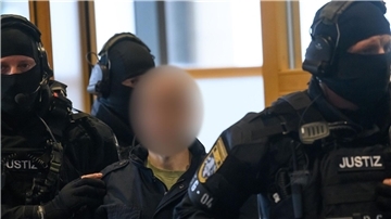 Justitzbeamte führen den Angeklagten in den Gerichtssaal in Magdeburg.