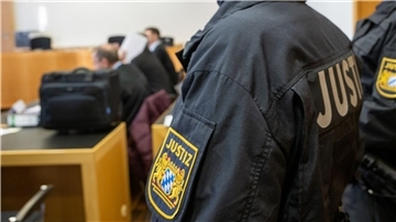 Justizangestellte bewachen im Strafjustizzentrum in Augsburg die Angeklagten.