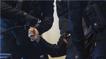 Justizbeamte nehmen dem Angeklagten Stephan Balliet im Gerichtssaal die Handschellen ab.