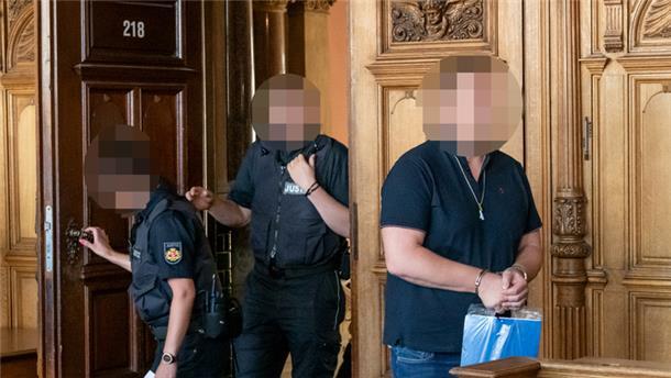 Drei Personen betreten einen Raum.