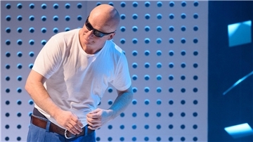 Ein Mann mit Glatze und Sonnenbrille