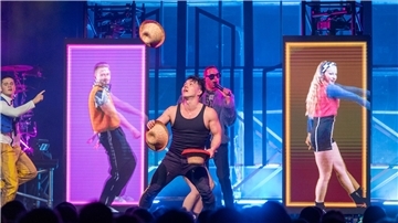 Ein Jongleur wirft Hüte in die Luft. 
