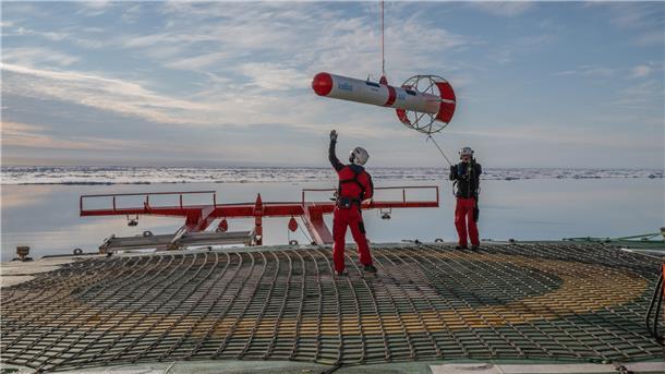 Kai Miehe (l) und Dwayne McOscar von dem Heli Team fangen den EM-Bird nach Eisdickemessungen ein