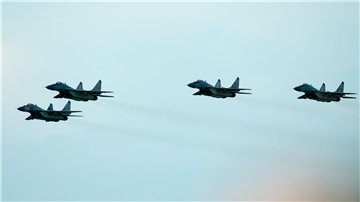 Kampfjets vom Typ MiG-29 fliegen während einer Flugshow in der Slowakei über einen Flughafen.