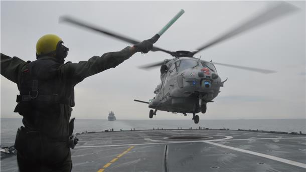 Ein Mann und ein Hubschrauber an Deck eines Schiffes