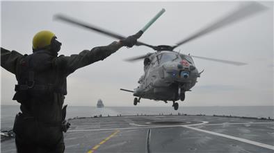 Ein Mann und ein Hubschrauber an Deck eines Schiffes
