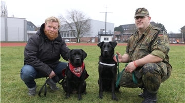 Kapitänleutnant Frederik Hesse (l.) sitzt neben seinem Hund „Dorle“, Hauptfeldwebel Alexander Schmidt von der Logistikschule der Bundeswehr in Garlstedt hat Therapiehund „Krümel“ an der Leine. Beide wollen darauf aufmerksam machen, dass die Zahl von Soldatinnen und Soldaten mit einer einsatzbedingten posttraumatischen Belastungsstörung seit Jahren steigt.