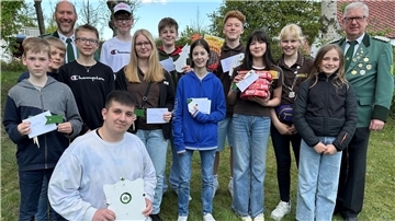 Gruppenfoto von Jugendlichen und zwei Schützen in Uniform beim Frühjahrsschießen des Schützenvereins Westerbeverstedt; die Jugendlichen halten Preise und Urkunden.