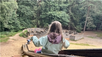 Ein Kind rutscht von der großen Rutsche. Spielplatz Zevener Holz.