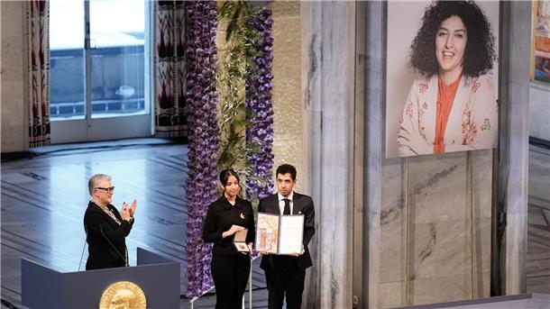 Iranerin Narges Mohammadi mit Friedensnobelpreis geehrt Kiana (l) und Ali Rahmani halten die Medaille und die Urkunde während der Verleihung des Friedensnobelpreises 2023 im Rathaus von Oslo. Die Zwillinge nehmen den Friedensnobelpreis stellvertretend für ihre inhaftierte Mutter entgegen.