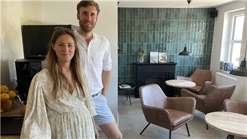 Kim Stoczczack und Thore Schreiber stehen in der Lounge, die als Frühstücksraum und als ein Ort für Begegnungen und Gespräche dient.